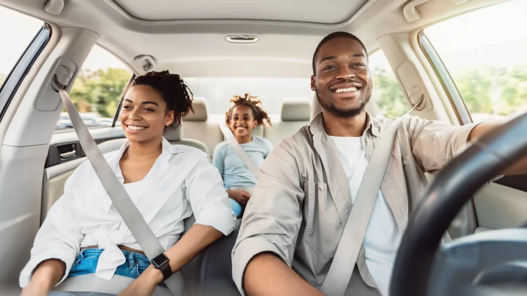 family in car smiling with affordable auto insurance in Freeland, MI