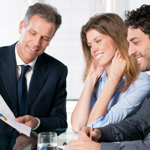 Insurance agent reviewing an Auto Home Insurance Bundle Policy with a Married Couple in Auburn, MI