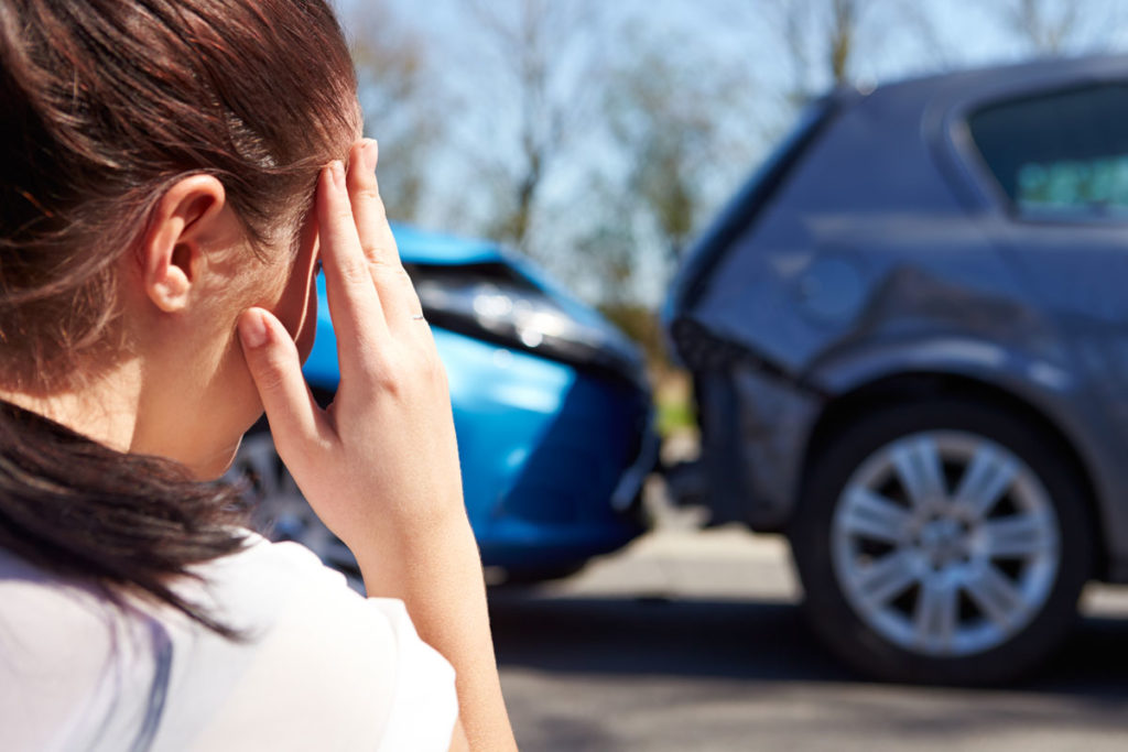a woman distraught after a car accident that requires Auto Insurance in Saginaw, MI