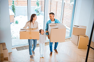 family carrying boxes with Cheap Homeowners Insurance in Auburn, MI